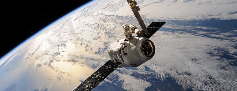 Spacecraft in orbit above Earth, illustrating the space activities that now require a licence from the UAE Space Agency