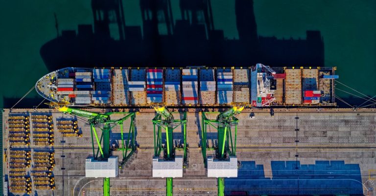 Aerial top view of a container ship loaded by gantry cranes at a port terminal, illustrating AD Ports Group record Q2 2026 results with AED 7.08 billion revenue