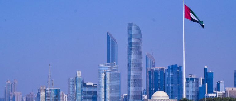 Abu Dhabi skyline and the UAE flag seen across the corniche, illustrating the Abu Dhabi Securities Exchange reaching around AED 2.9 trillion in market capitalisation