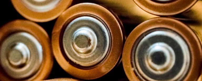 Close-up of cylindrical battery cells with metal terminals, illustrating battery anode materials