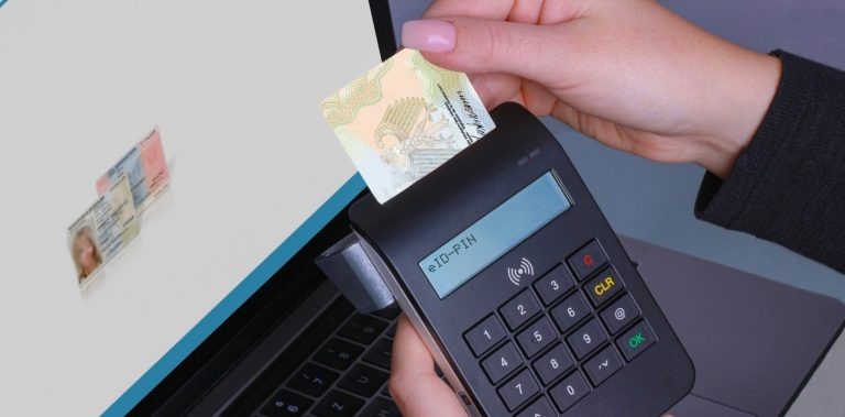 Electronic ID card being inserted into a card reader beside a laptop showing a verified identity document, illustrating the UAE plan to pull bank customer data from official sources