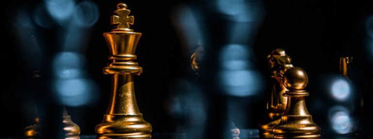 Gold chess king in focus among blurred pieces on a dark board, illustrating Gulf dealmaking ahead of the Private Capital Summit Dubai on 15 September 2026