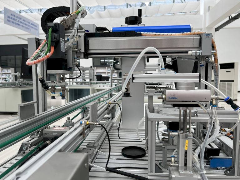 Modern automated production line with gantry axis, cable chain and pneumatic actuators in a bright factory hall, illustrating the Factory Forward UAE platform for Industry 4.0 adoption