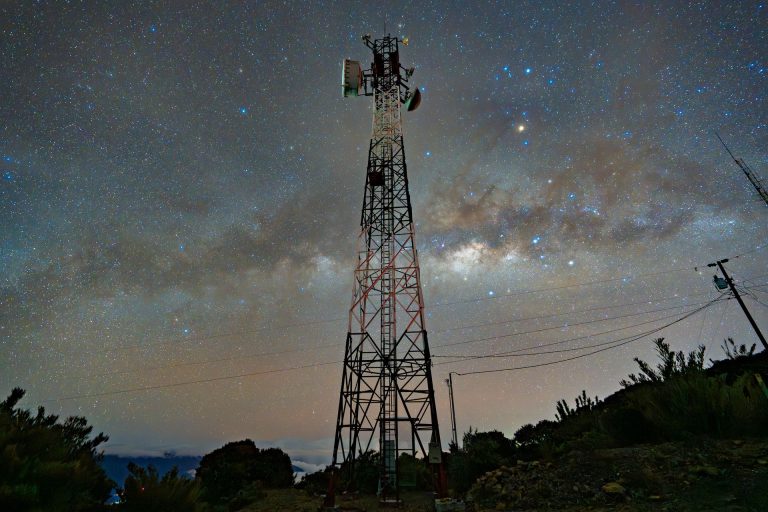Mobile telecom tower with antennas under a starry night sky and the Milky Way, illustrating Equatys, the Space42 and Viasat satellite network planned to extend mobile coverage