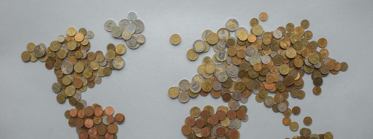World map made of coins from many countries on a grey surface, illustrating non-resident deposits in UAE banks at AED 311.4 billion at the end of July 2026