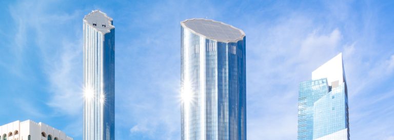 Glass skyscrapers in central Abu Dhabi against a clear blue sky