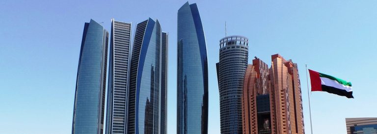 Etihad Towers in Abu Dhabi with the UAE flag, home of the UAE Ministry of Investment