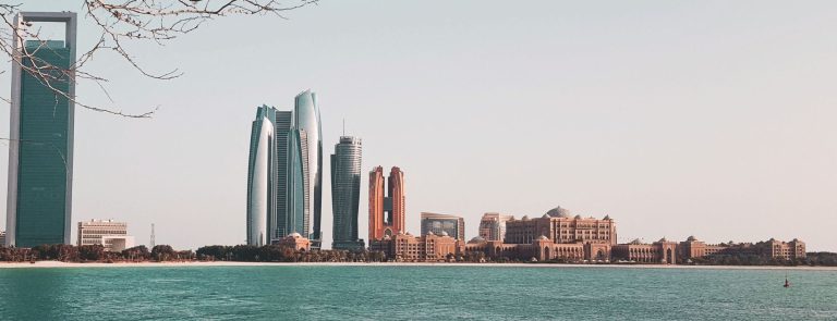 Abu Dhabi skyline across the water with the ADNOC headquarters, Etihad Towers and Emirates Palace