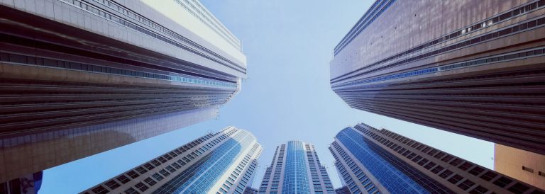 Low angle view of glass high-rise towers in Abu Dhabi against a clear blue sky