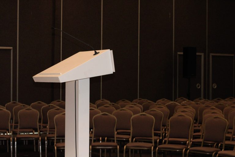 Speaker podium with a microphone in an empty conference hall, illustrating Dubai hosting the Concordia Horizon Summit in May 2027