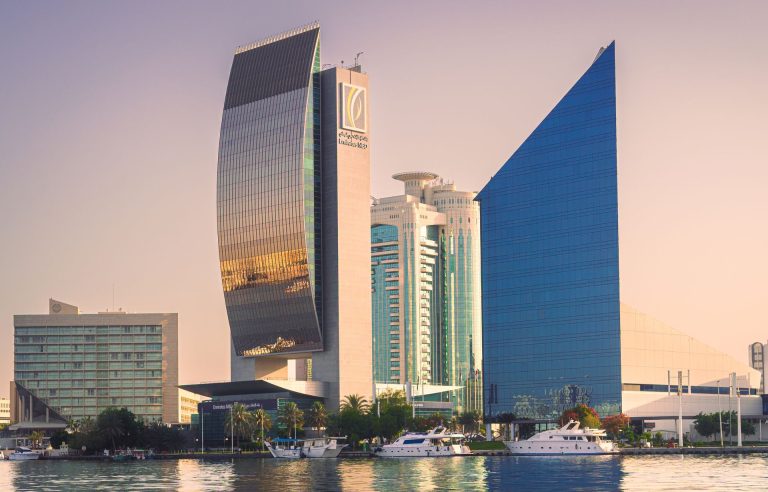 Emirates NBD tower and neighbouring office buildings on the Deira bank of Dubai Creek at sunset