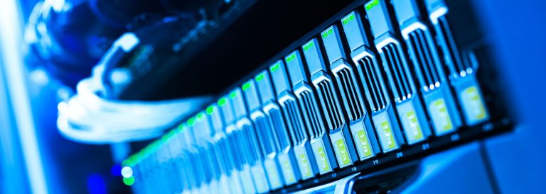 Row of server drive bays with green indicator lights in a blue-lit data centre
